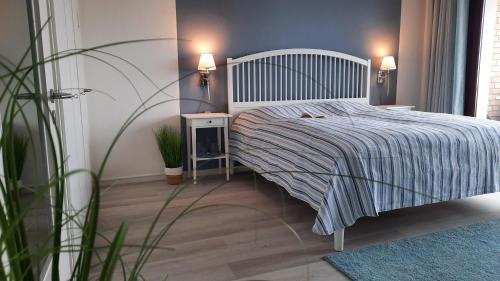 ein Schlafzimmer mit einem Bett mit einer gestreiften Decke in der Unterkunft Ferienwohnung Wattkieker in Büsum