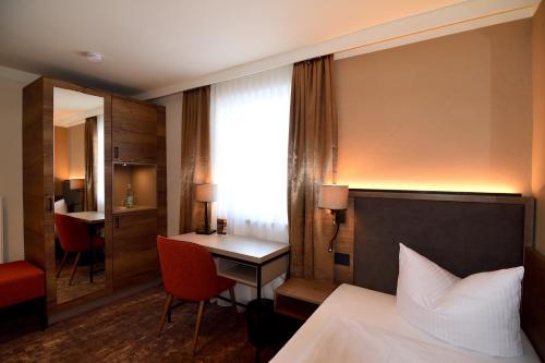 a hotel room with a bed and a desk at Lindenberger Hof in Lindenberg im Allgäu