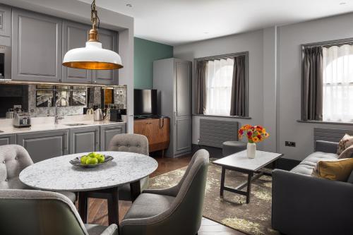 a kitchen and living room with a table and chairs at Hapimag Apartments London in London