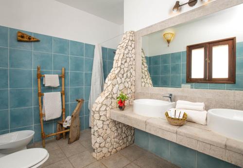 een badkamer met 2 wastafels en een bad bij Mvuvi Boutique Resort in Kiwengwa