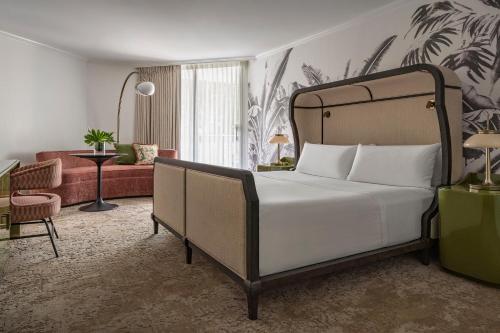 a bedroom with a bed and a living room at PGA National Resort in Palm Beach Gardens