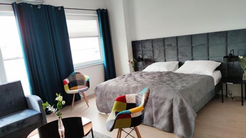 een slaapkamer met een groot bed en 2 stoelen bij Hotel ANTARES in Sępólno Krajeńskie