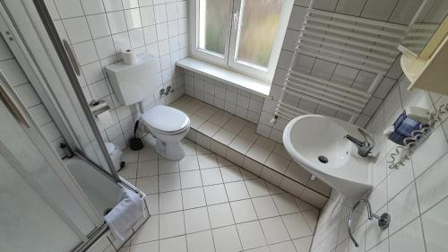 a bathroom with a toilet, sink, and tub at Bornholmer Hof im Prenzlauer Berg in Berlin