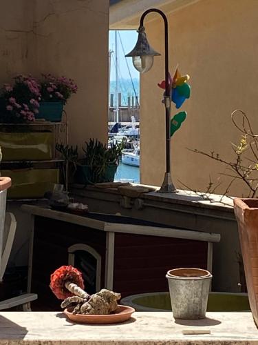 a table with a fireplace with a lamp and flowers at Casetta del borghetto -Nel cuore del Borghetto in Nettuno