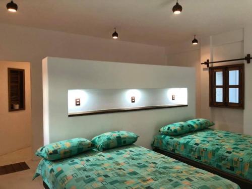 a bedroom with two beds with pillows on them at Cabañas las Palmas Chacahua in Yegüey
