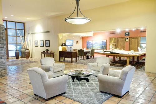 a living room with white chairs and a table at Starr Pass Golf Suites in Tucson