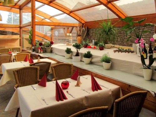un restaurante con mesas y sillas con servilletas rojas. en Jetenburger Hof, en Bückeburg