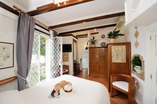 um quarto com uma cama com um chapéu em Villa Oliver - Breathtaking small Pool 14 sqm Hydromassage on the Rock - Amalfi Coast em Amalfi