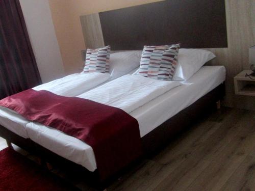 a large white bed with two pillows on it at Jetenburger Hof in Bückeburg