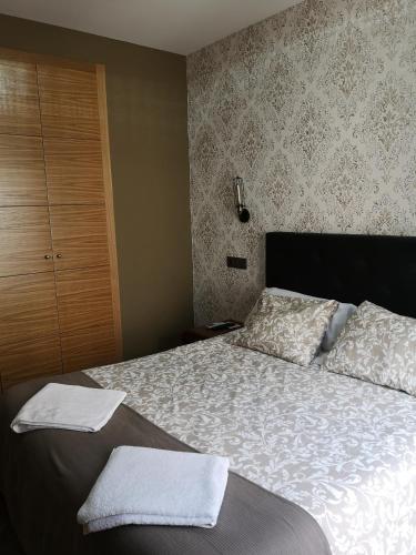 a bedroom with a bed with two towels on it at Hostal Juan Bravo in Segovia
