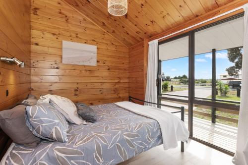 En eller flere senger på et rom på Bream Bay Sands - Ruakaka Holiday Home