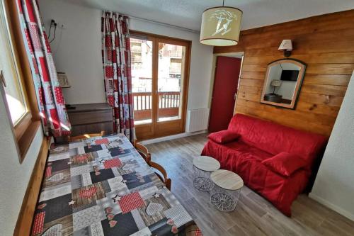 sala de estar con sofá rojo y mesa en Logement 4/6 personnes à la montagne avec piscine, en Saint-Sorlin-dʼArves