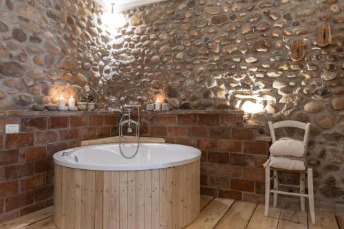 a bathroom with a wooden tub in a brick wall at GardaBeds Adults Only in Castelnuovo del Garda