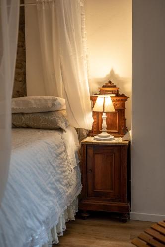 a bedroom with a bed and a lamp on a night stand at GardaBeds Adults Only in Castelnuovo del Garda