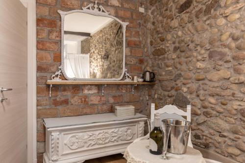 a bathroom with a mirror on a brick wall at GardaBeds Adults Only in Castelnuovo del Garda