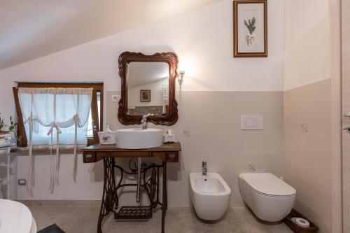 a bathroom with a sink and a toilet and a mirror at GardaBeds Adults Only in Castelnuovo del Garda