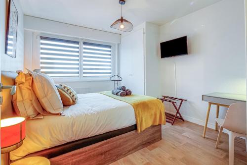 een slaapkamer met een bed, een bureau en een raam bij AlsaceTime, CENTRE Parking gratuit, TRAM WIFI, Fibre Orange, espace de travail in Straatsburg