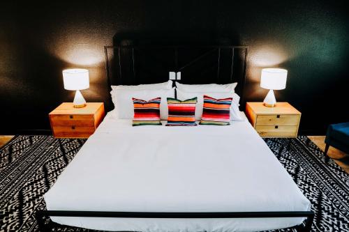a bedroom with a large white bed with two lamps at Wimberley Inn & bar in Wimberley