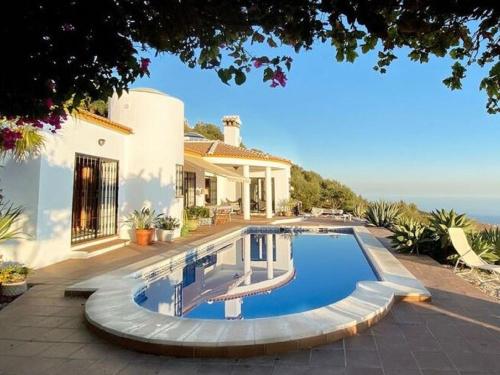 a swimming pool in front of a house at Belvilla by OYO Villa in Arenas with Private Pool in Arenas