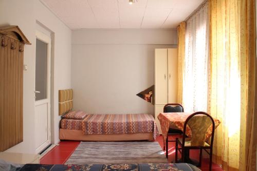 帕莫卡萊的住宿－Karaca Termal Pansiyon，卧室配有1张床、1张桌子和1把椅子