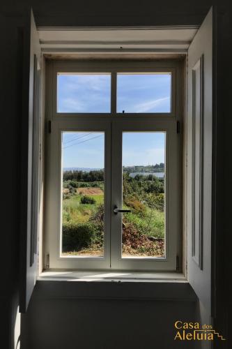 a window with a view of a field through it at Casa dos Aleluia in Coimbra