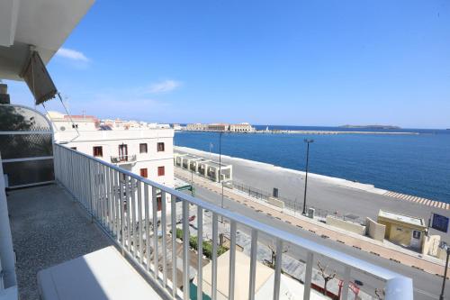 a balcony with a view of the ocean at Welcome Home Syros Port Apartment in Ermoupoli