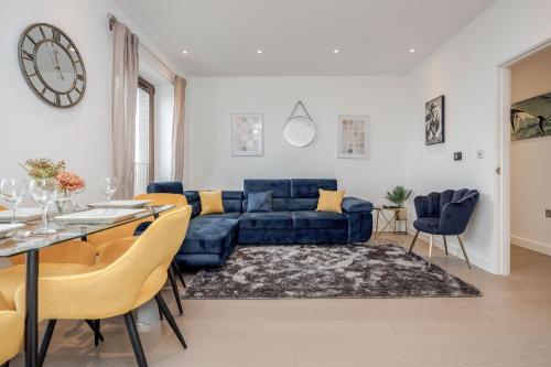 a living room with a blue couch and a table at LillyRose Serviced Apartments - St Albans City Centre, Parking in St. Albans