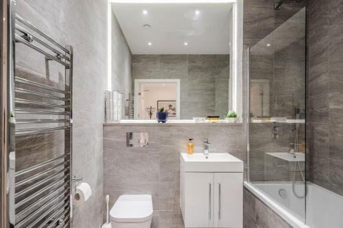y baño con aseo, lavabo y ducha. en LillyRose Serviced Apartments - St Albans City Centre en Saint Albans