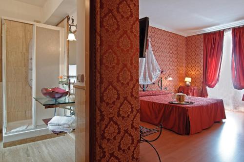 ein Schlafzimmer mit einem roten Bett und einem kleinen Tisch in der Unterkunft Residenza Antica Roma in Rom