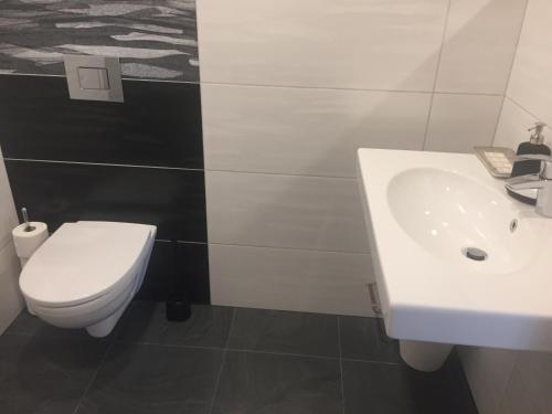 a bathroom with a white sink and a toilet at Penzion Za radnicí in Valtice