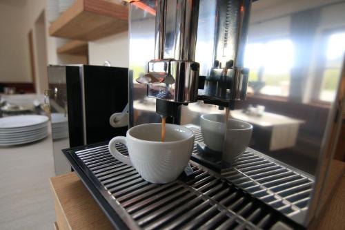 two cups of coffee are sitting on a drying rack at Alpinhotel Berchtesgaden in Berchtesgaden