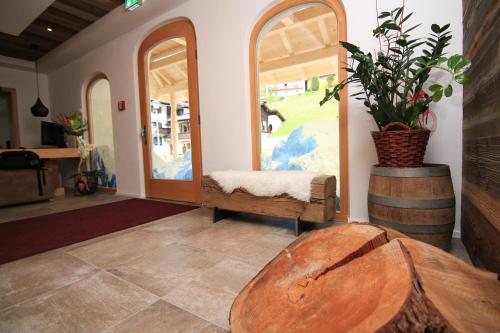 a living room with a table and a plant in a barrel at Alpinhotel Berchtesgaden in Berchtesgaden
