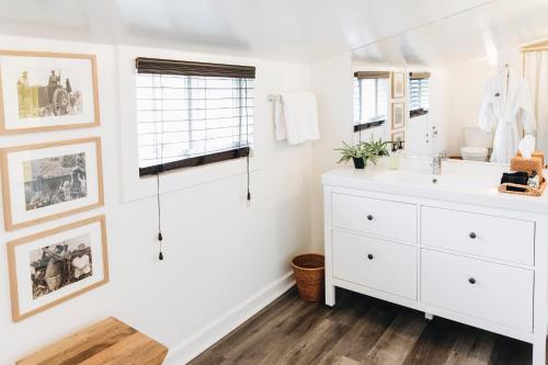 a white bathroom with a sink and a mirror at Sonoma's Best Guest Cottages in Sonoma