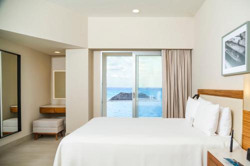 a hotel room with a bed and a view of the ocean at Emporio Cancun - Buy All Inclusive Option in Cancún