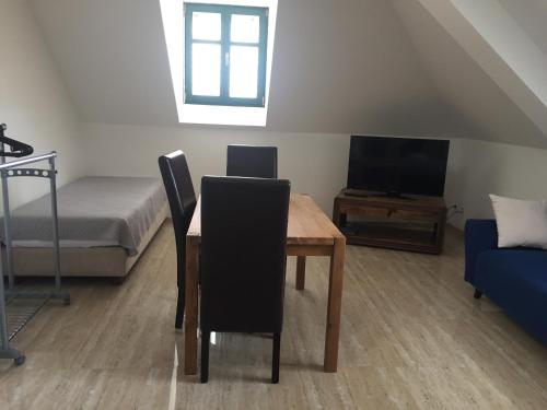 a room with a table and a bed and a television at Penzion Za radnicí in Valtice