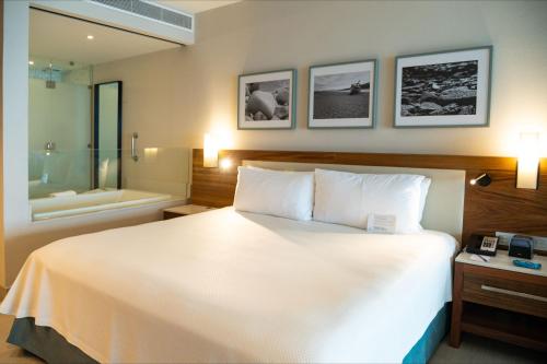 a hotel room with a bed and a bath tub at Emporio Cancun - Buy All Inclusive Option in Cancún