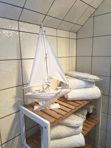 a toy sail boat on a shelf in a bathroom at Orchidee in Niebüll
