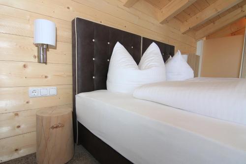a bedroom with a bed with white pillows at Alpinhotel Berchtesgaden in Berchtesgaden