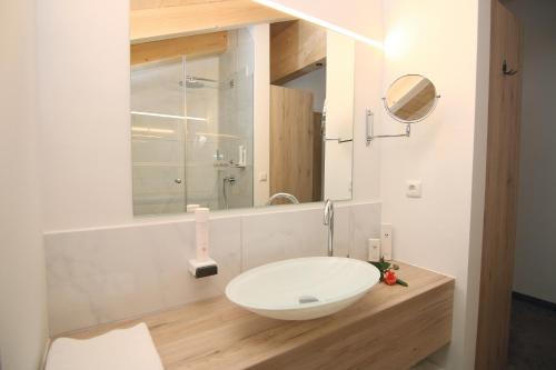 a bathroom with a white sink and a mirror at Alpinhotel Berchtesgaden in Berchtesgaden