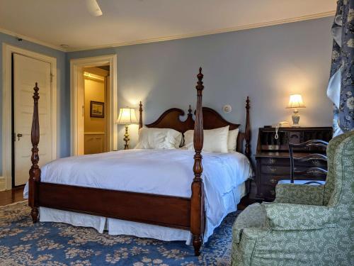 a bedroom with a bed and a chair at Stanton House Inn in Greenwich