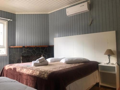 a bedroom with a bed with two towels on it at Apartamentos Sulla Collina Centro de Gramado localizado próximo da rua Coberta in Gramado