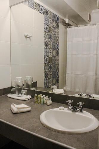 a bathroom counter with a sink and a mirror at Hotel Antigua Miraflores in Lima