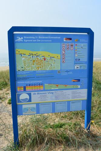a sign on the beach near the beach at Strandhotel Golfzang in Egmond aan Zee