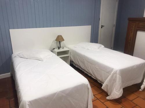 two beds sitting next to each other in a room at Apartamentos Sulla Collina Centro de Gramado localizado próximo da rua Coberta in Gramado