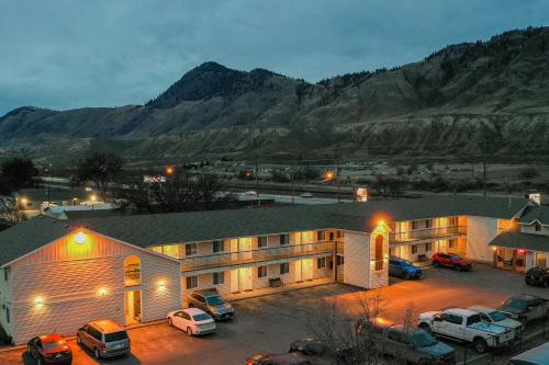 カムループスにあるThe Ranchland Inn Kamloopsの駐車場に車が駐車されている大きな建物