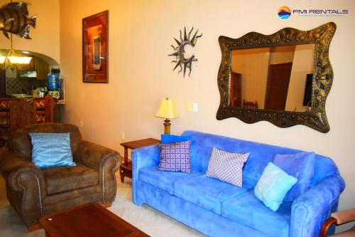 a living room with a blue couch and a mirror at Marina Pinacate B-118 in Puerto Peñasco