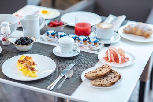 a table with plates of breakfast food on it at Best Western Hotel Quattrotorri in Perugia