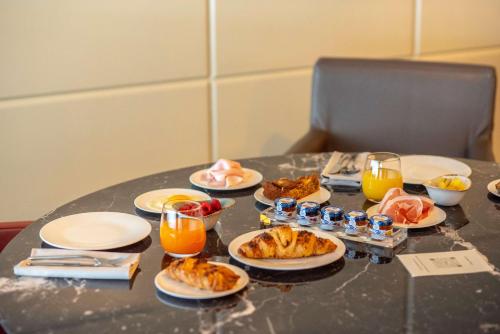 a table with plates of food and glasses of orange juice at Best Western Hotel Quattrotorri in Perugia