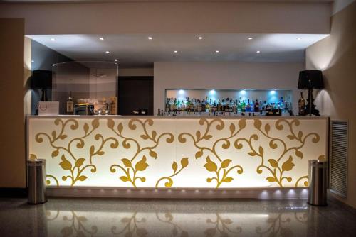 a bar at a hotel with a gold patterned wall at Best Western Hotel Quattrotorri in Perugia