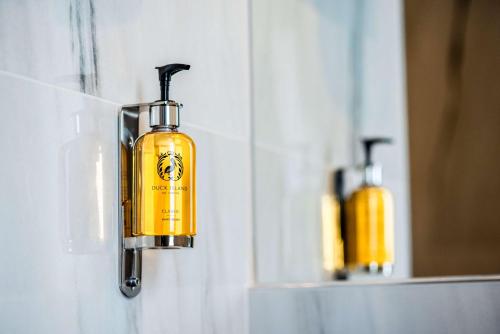 a yellow soap dispenser hanging on a wall at Best Western Hotel Quattrotorri in Perugia